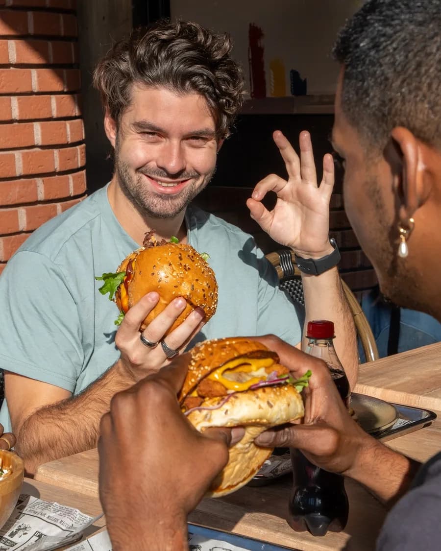 Deux amis qui se régalent avec leurs burgers